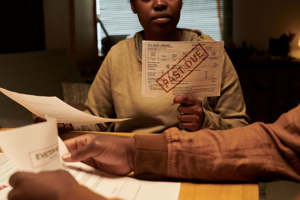 A couple sitting in their home reviewing past due bills.